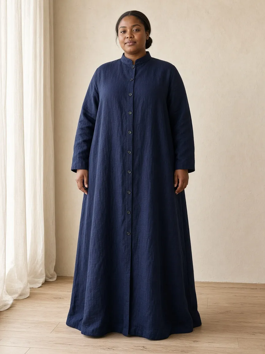 Studio photograph of a model wearing the Navy Linen Duster: floor length, long sleeves to the wrist, stand collar, buttoned through